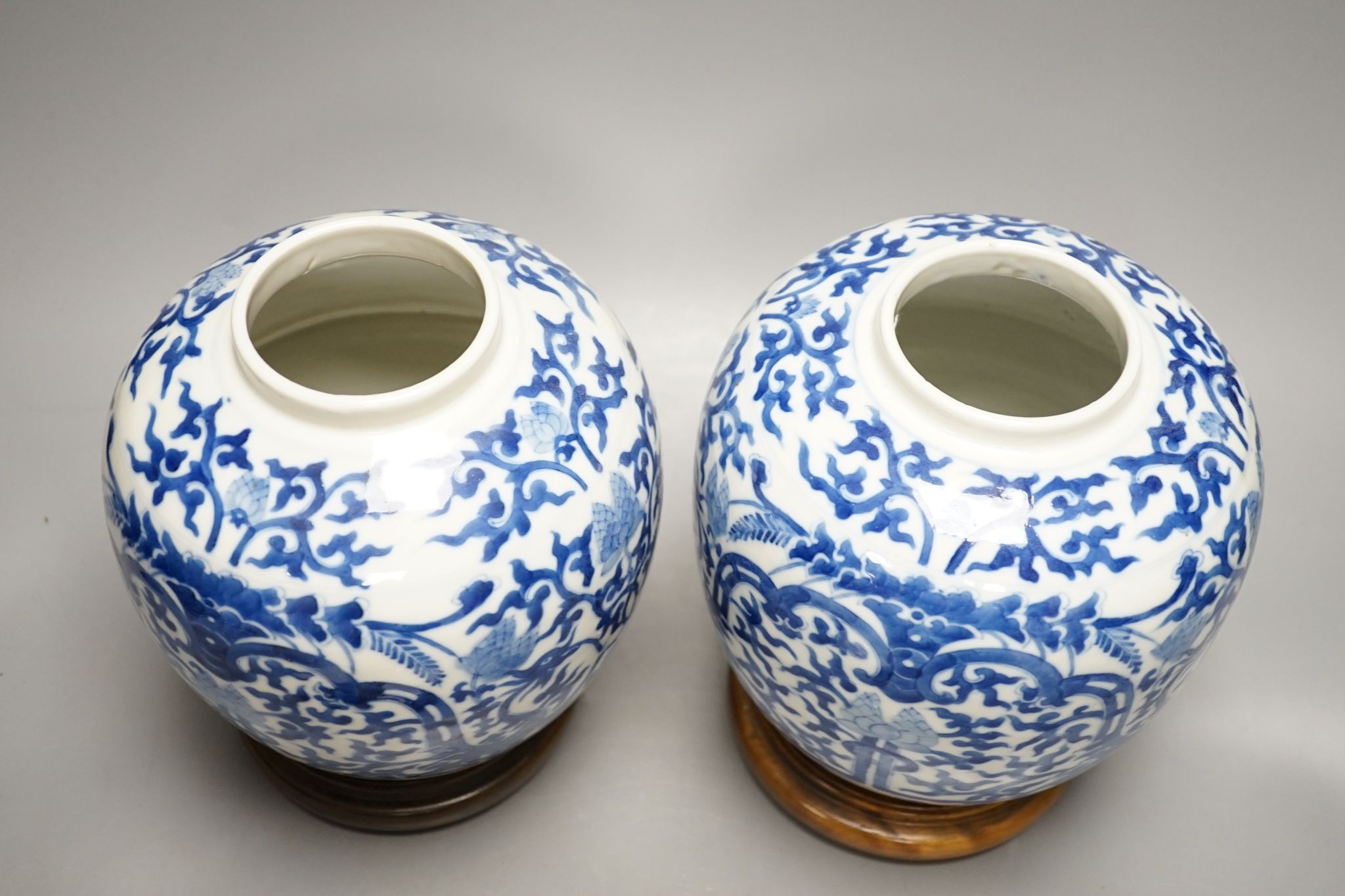 A pair of Chinese blue and white ginger jars and covers, 22cm, On stands
